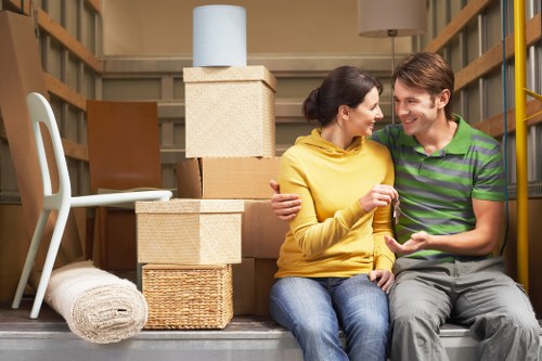 Movers transporting furniture from an Elephant and Castle flat with protective equipment